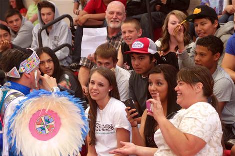 Supaman performs a freestyle rap as people in the audience hold up items to trigger his rhyme.