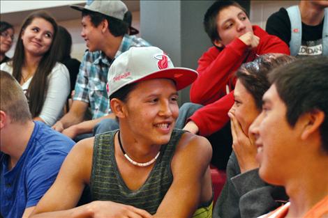 Supaman asks students to turn to the person sitting next to them and smile, saying being positive makes people feel better.