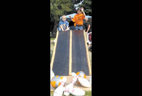 Children enjoy bowling with pumpkins at Ronan Harvest Fest.