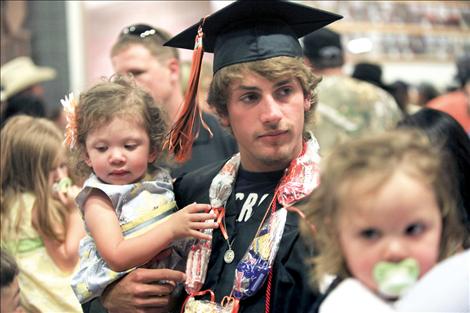 Connor Benn holds his little sister after graduating from Ronan High. Benn earned a football scholarship to MSU-Northern.
