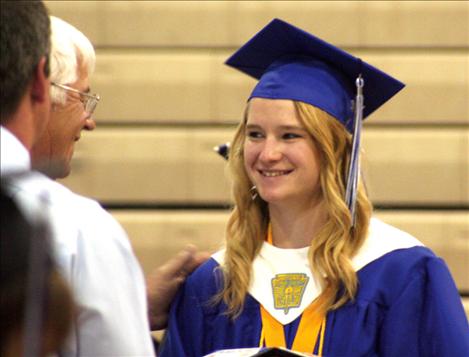 Valedictorian Carley Elverud walks across the stage to get her diploma after singing the graduates through four years of high school.