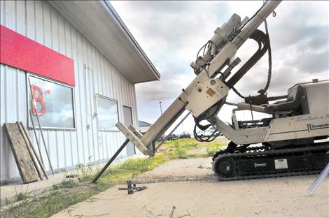 A machine bores into the ground to sample suspected contaminated soil at George’s Conoco in Ronan. 