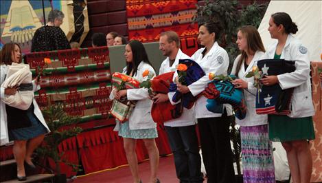 Nursing student graduates stand with their Pendelton blankets.