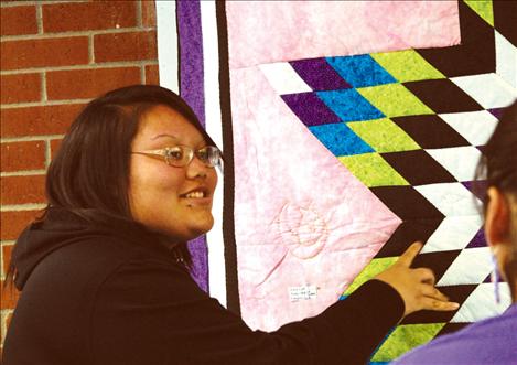 Maklit Charlo shows her star quilt to a friend at Two Eagle’s Art Slam.