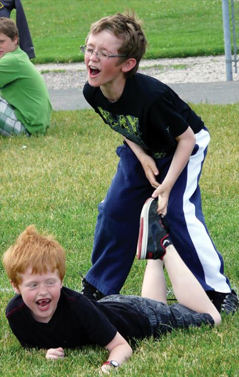 George Wyman, above right, lifts classmate Quinton Clark during the wheelbarrow race at the second grade field day.