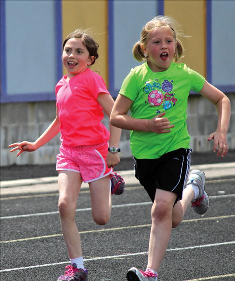 Aspen McKee, left, and Grace Simonich sprint during third grade field day.
