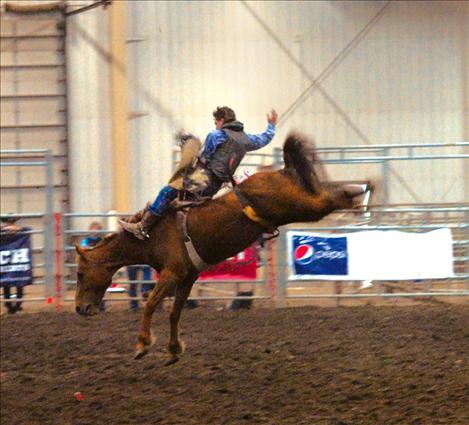 Trevar McAllister spurs his bareback horse at the Montana High School Rodeo Finals in Kalispell.