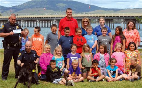 Llop and handler Officer Juan Maso, left front, visit with a group of second graders. Tim Lake, back left, board member for Northwest Farm Credit Services, stands next to Joey Hennes, manager for Northwest Farm Credit Services, Missoula, who presented Polson Police Chief Wade Nash with grant money for Llop’s care and feeding.