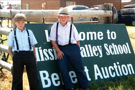 Boys hang around the sign advertising the auction.