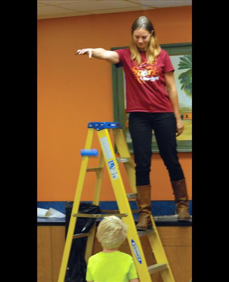 Martel Memmer, youth services librarian, drops a participant’s egg as he watches.