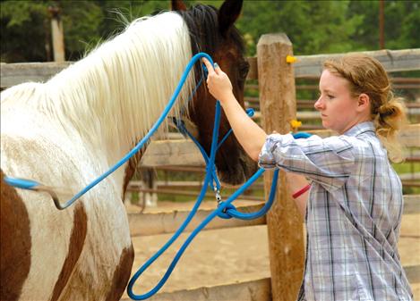 Marissa Reber  works with her  mother’s horse,  flipping a soft cotton  rope over the  mare’s back and  around her legs.