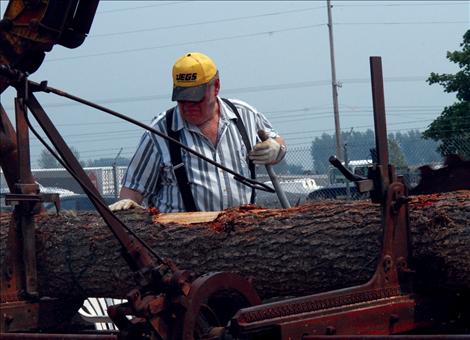 Larry Eslick turns a log at the museum’s sawmill.