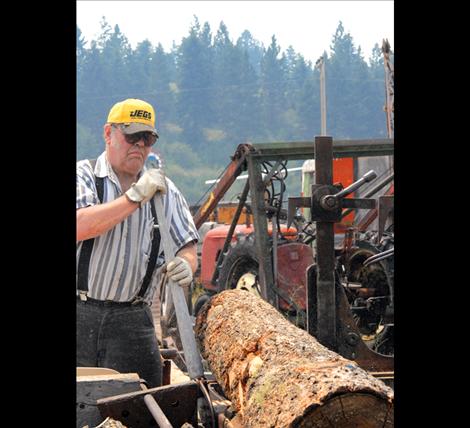 Larry Eslick turns a log at the museum’s sawmill.
