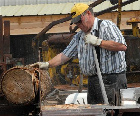 Larry Eslick turns a log at the museum’s sawmill.