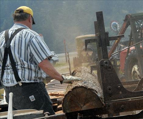 Larry Eslick turns a log at the museum’s sawmill.