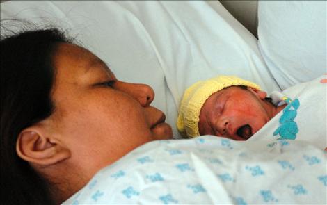 Mathias Lee Buckskin snuggles with his mother Sharon Lee Buckskin after being born on a local transit bus. 