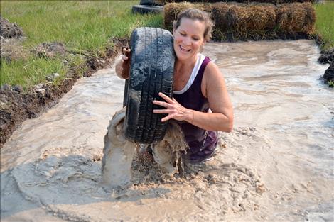 Dee Dee Haines of Ronan keeps her spirits high a she sloshes through the sloppy course.