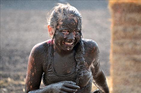 Faith Olson grins through a mud mask.