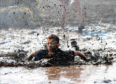 Isaiah Silgen finishes the Boys and Girls Mud Run obstacle course Saturday morning with a belly flop into the mucky mud pit.