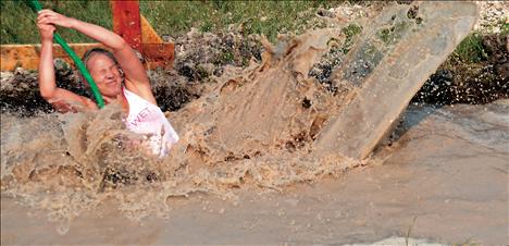 A runner misses the far side of the rope swing and lands in a puddle.