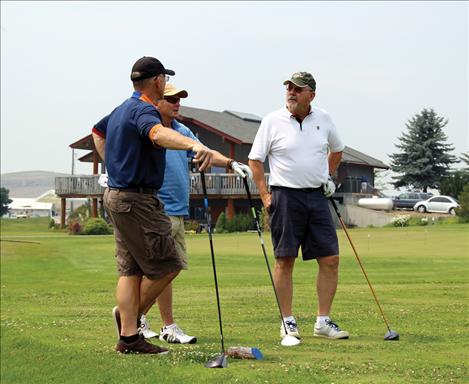 Bob Nockleby, Mark Castro and Ray Aylesworth huddle on the green. 