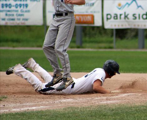 Alex Killian dives back to first base.