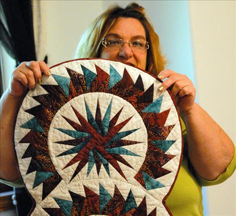 Charlotte Sheumaker, Pat’s friend and sewing companion, holds up a sample of Pat’s work from a Judy Niemeyer pattern. This was a class piece, and Pat enjoyed sewing with the other ladies.   