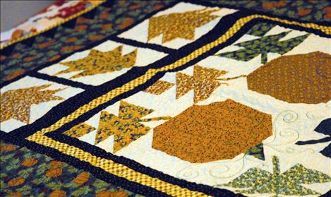 A Thimbleberries quilt, featuring pumpkins, yellows, greens and blues is one of at least 80 quilts in Pat Anderson’s house.