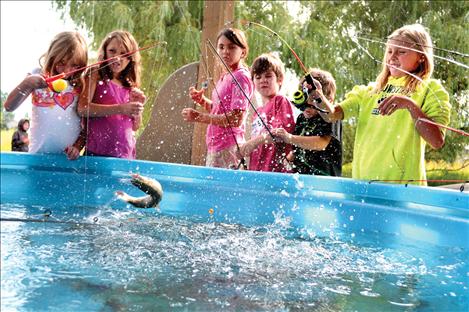 A rainbow trout snags a line as groups of young anglers crowd around a fish tank at the annual fishing derby, held Saturday at Ronan’s Bockman Park during Pioneer Days.