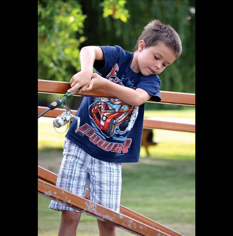 Paxton McConnell fishes from the bridge with help from his grandfather.