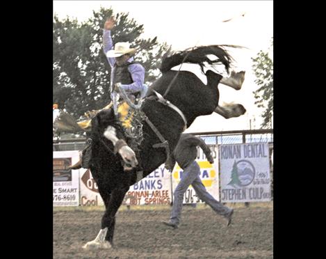 Andrew Evjene of Melville rides a saddle bronc for 8 seconds, earning a score of 81 during Friday night’s Broncs and Bulls Rodeo.