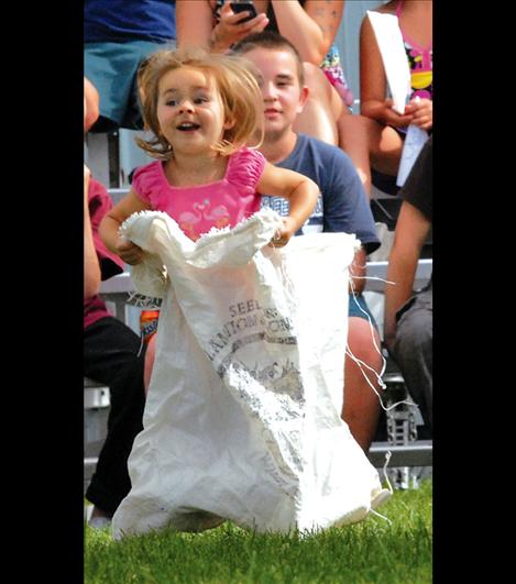 Katherine Bartel, 3, bounces her way through the sack races sponsored by the Lions Club July 30.