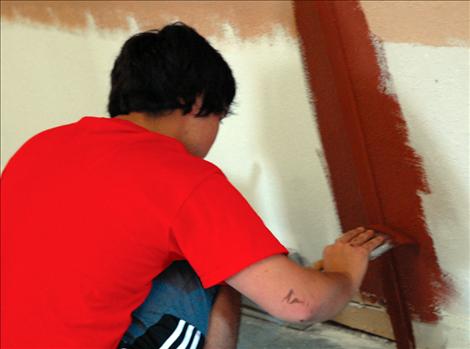 Workmen begin plastering, painting and trimming the halls and room
