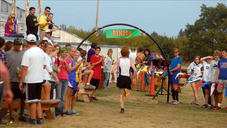 Jimmy Bjorge, PHS varsity runner, sprints to the finish line at the Polson Invitational on Sept. 22. The course included hay bales and log obstacles and a run through the calf chutes.