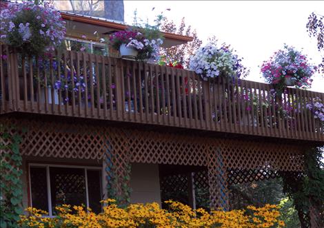  Flowering plants on the deck, flowerbeds, and lots of ornamental trees grow all over Bertsch’s property on Memory Lane. 