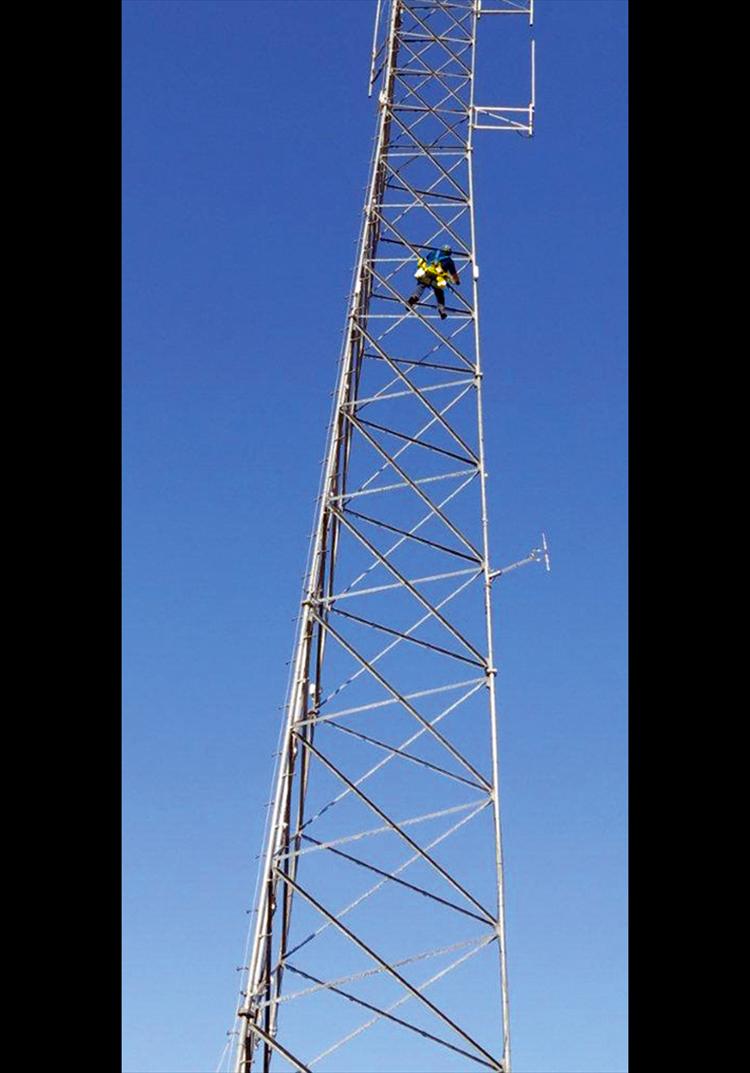 Watch that step - Rick Kiehn of Access Montana climbs a communication tower Thursday at Salish Kootenai College in Pablo. While you can’t beat the birds eye view, a climb like this isn’t for the faint of heart. 