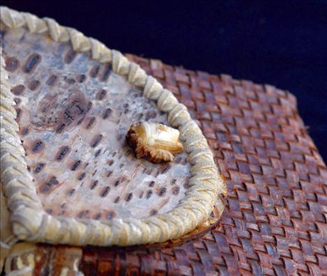 Carved from an antler, “the watcher” serves as a closure for a woven bag made by Dion Albert.