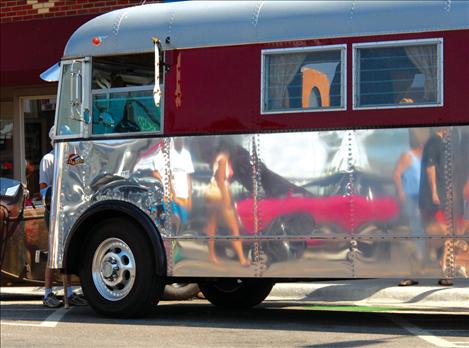 The shiny “skin” of Char and Jerry Appel’s 1937 coach turned into a motorhome reflects car show attendees. 