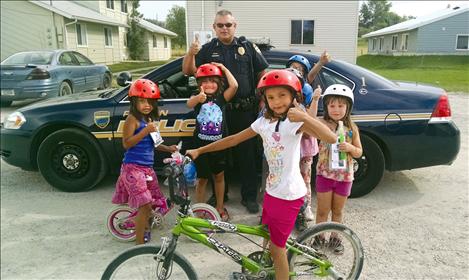 courtesy photo Polson Police Chief Wade Nash gives safety helmets to children in Polson.