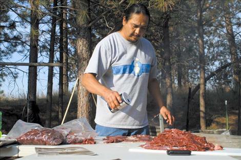 Mike Irvine prepares venison for the drying rack by salting and sorting different cuts of meat.