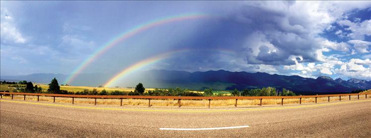 A double rainbow sweeps color across an otherwise cloudy Polson sky.