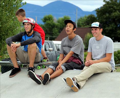 Bradley Pichler, Eddie Woodcock, and Jayson Pichler watch Skate Jam competitors.
