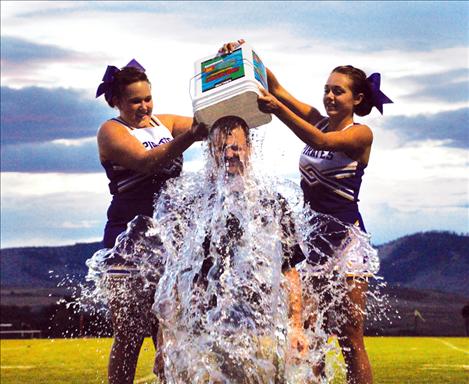 Polson High School Principal Rex Weltz shivers under a river of ice cold water after accepting the ALS Ice Bucket Challenge.  The challenge has gained popularity recently, as participants pour a bucket of ice water over their heads in an attempt to raise awarness for amyotrphic lateral sclerosis. 