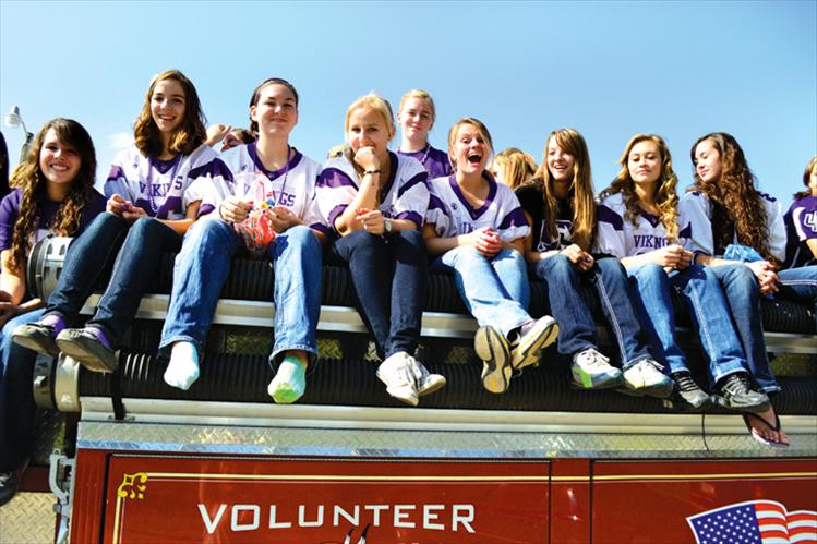 The Charlo volleyball team rides atop a fire truck in Friday’s homecoming parade.