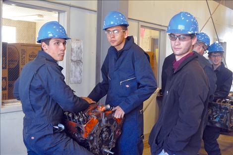 Megan Strickland/Valley Journal Austin Aucone, left, Billy Phillips and Justin Dunbar work on a motor in a Kicking Horse mechanics class.