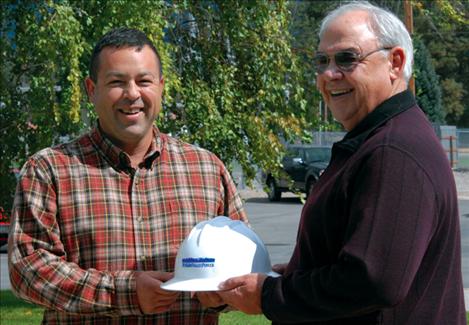 Ralph Goode, right, hands overs his Mission Valley Power hardhat to Jean Matt. 