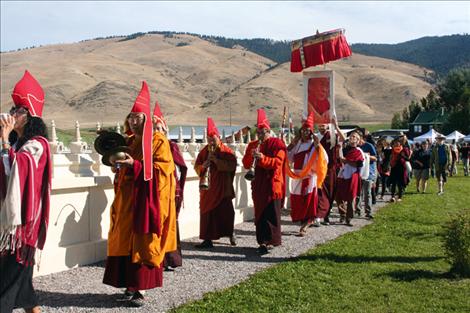 Tulku Sang-ngag Rinpoche hosts a parade to bless new additions to the garden, including eight plaques in different languages containing a prayer.