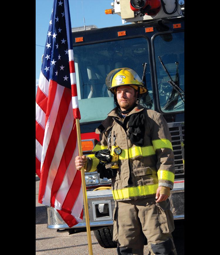Polson firefighter Blake Holman takes his turn standing for the 9-11 fallen firefighters. The firefighters took turns standing for hour-long shifts from 7 a.m. to 7 p.m.