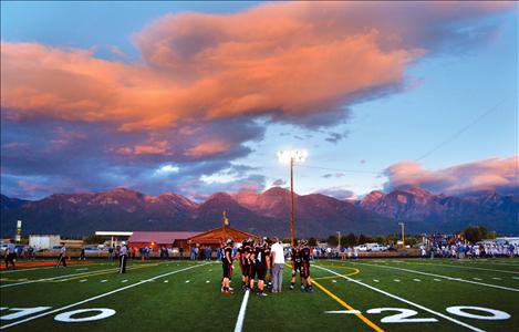 The Ronan Chiefs huddle up Friday evening on their own turf in front of the scenic Mission Mountains.