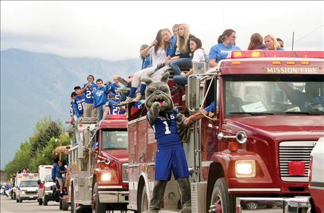 Mission High School football players parade through St. Ignatius Friday afternoon, a day before their homecoming game. 